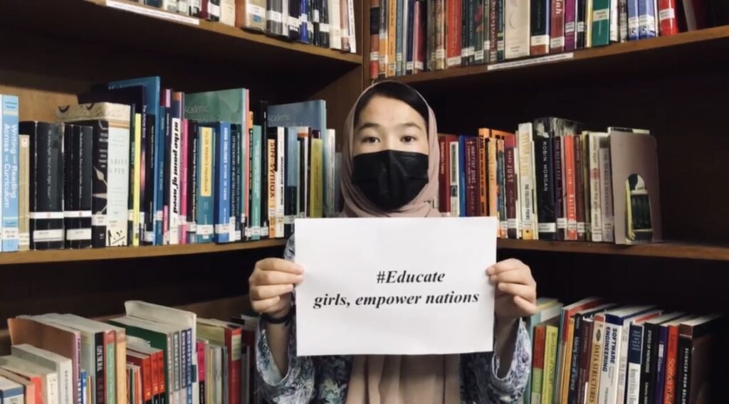 Afghan girl holds a pro-education poster