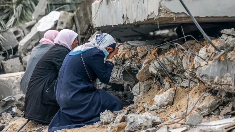 Women in Gaza take shelter behind rubble